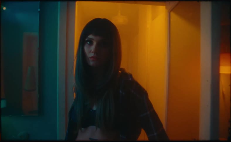 A woman walks into a room from a hallway looking nervous