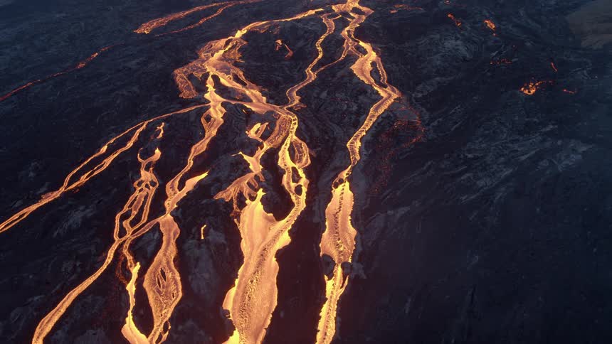 An aerial view of lava flowing from a volcano