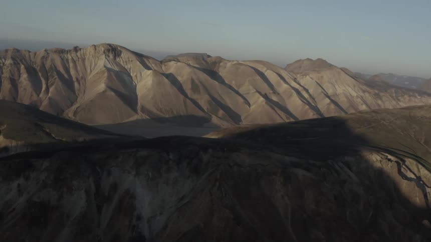 Parts of mountain range remain in shadow and other are litby sunlight