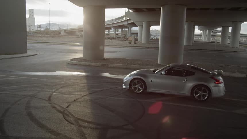 A silver car under an overpass