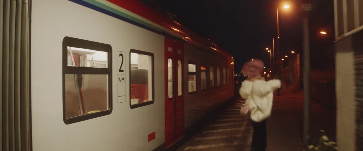 A woman running next to a train at night