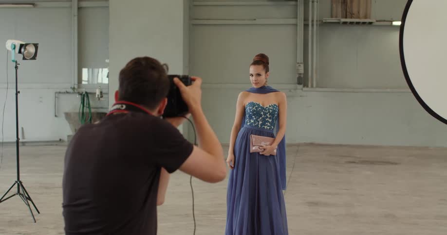 A woman is getting her picture taken while wearinga dress