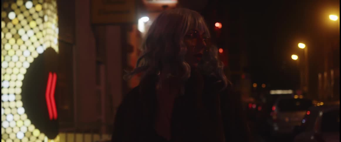 A woman stops to look behind her while walking downtown