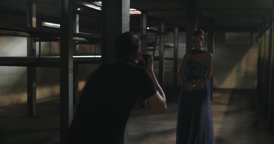 A photographer takes photos of a model in a prom dress