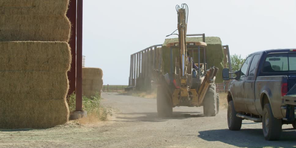 A tractor hauls bales of hay