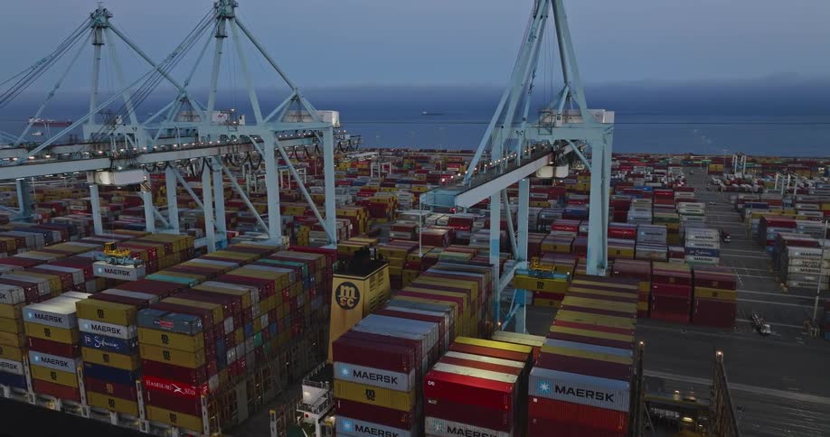 Cranes lifting shipping containers on the coast