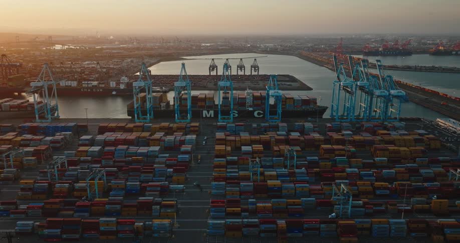 Cargo containers sit in neat rows at a shipping port