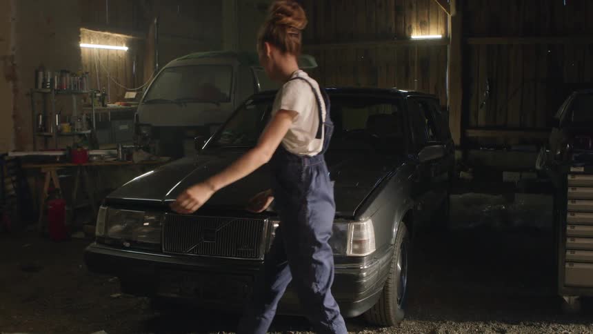 A woman opens up the hood of her vehicle