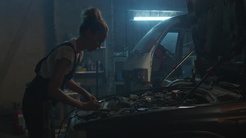 A woman repairs an engine