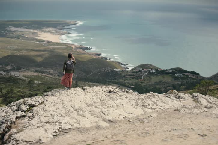 There is a person that is standing in front of the ocean