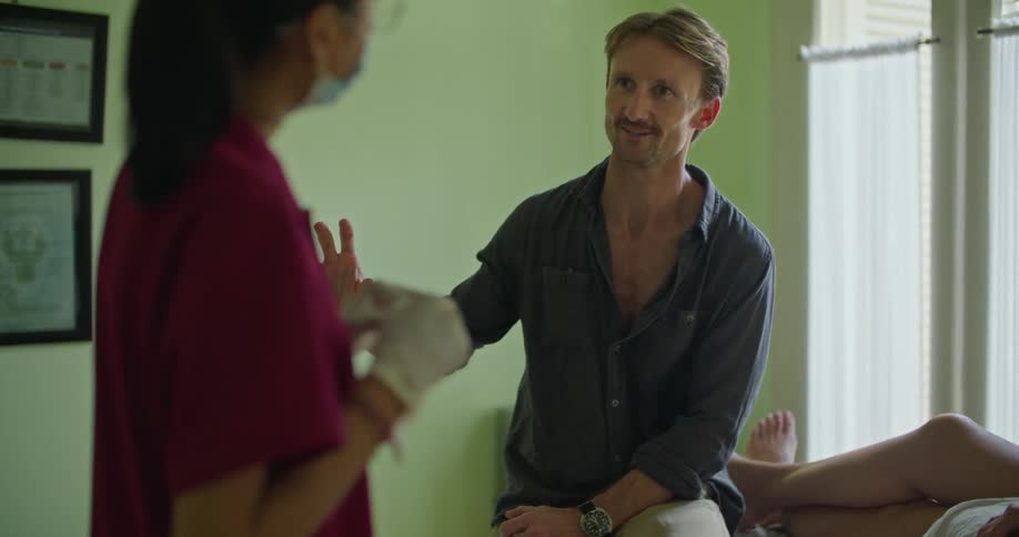 A nurse listens to a patient in a doctors office