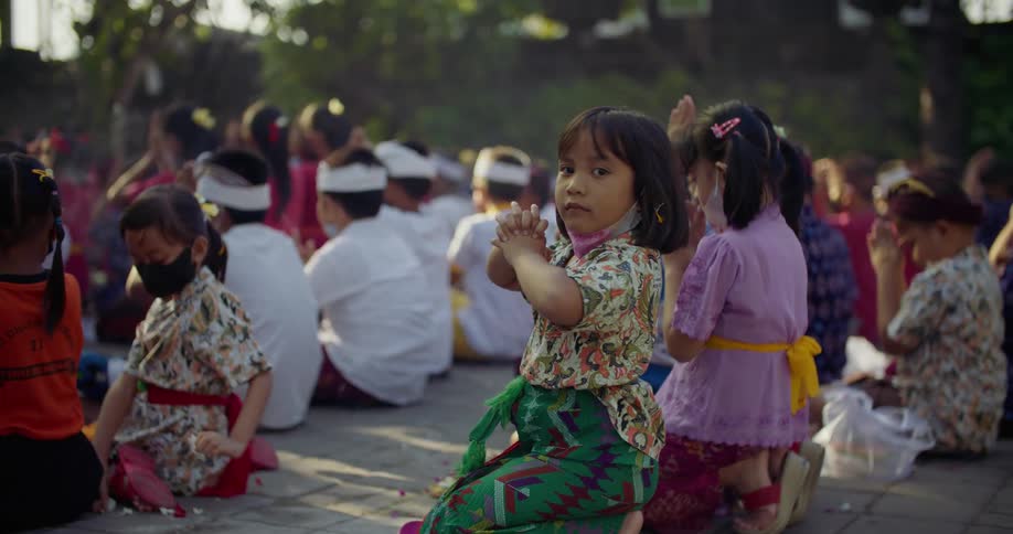 Children are sitting around praying together