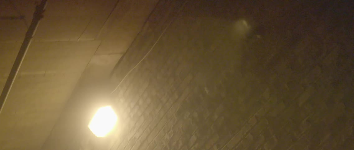A light on a brick wall is blinking rapidly