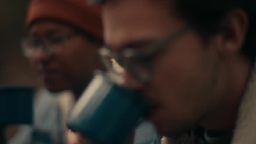 Two men camping drink from tin cups