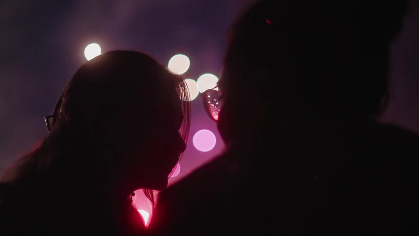 A man looks at his girlfriend during a fireworks show