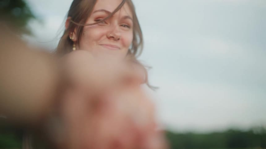 A woman holds hands and walks outside