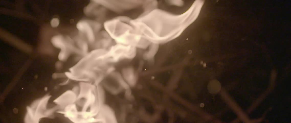 A log is on fire with sparks flying off it