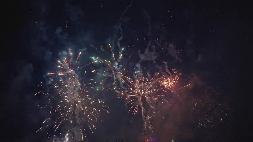 A couple embrace while watching a firework show