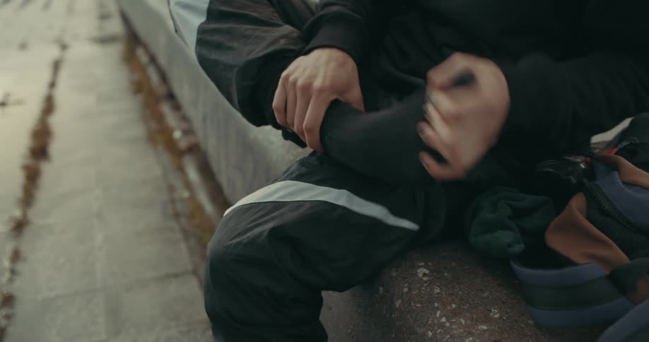 A person putting on socks outdoors