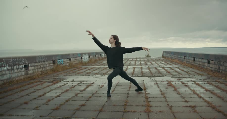 A man dances on a dock