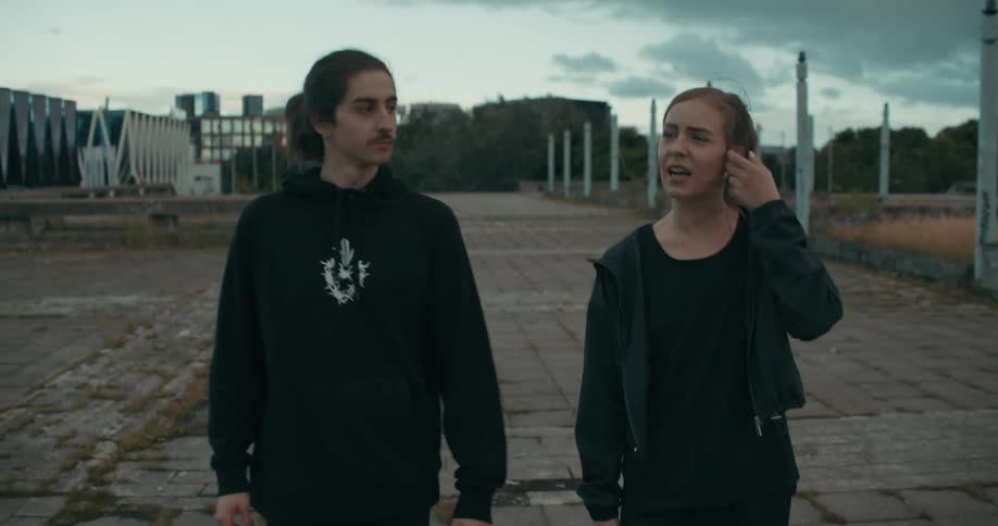 A man and woman chat while walking downtown