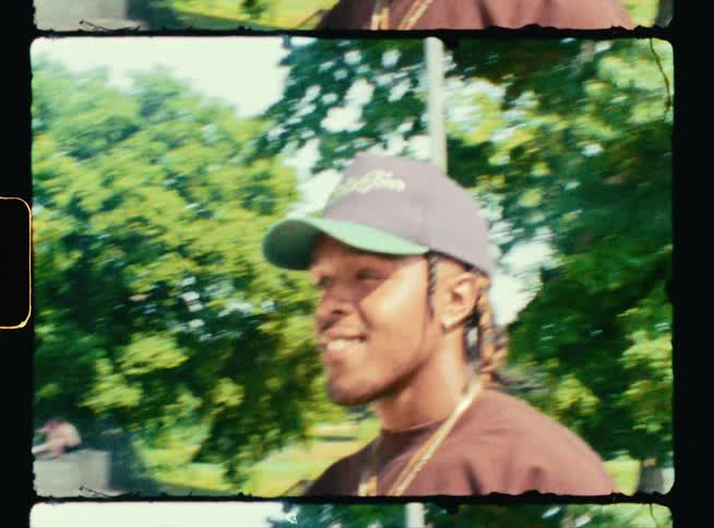 A young man smiles while he stands at an outdoor skate park