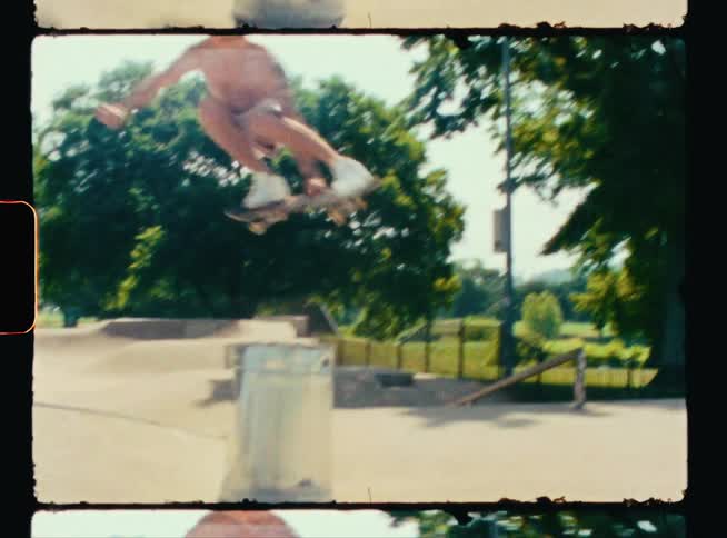 A man jumps over a garbage can with his skateboard
