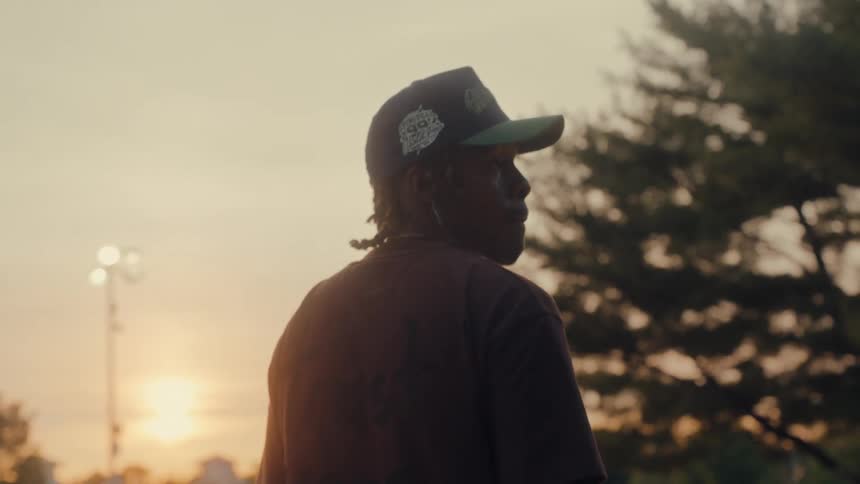 A man standing in a park looking around at sunset