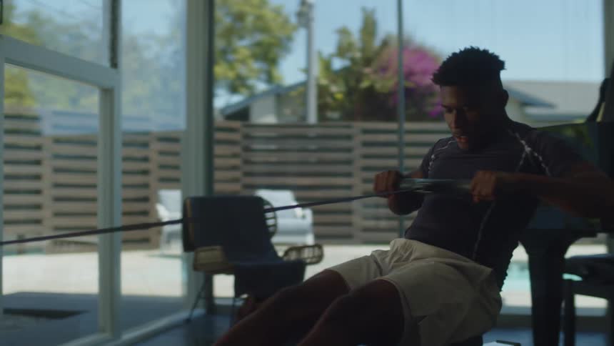 Young black man is working out inside of his home