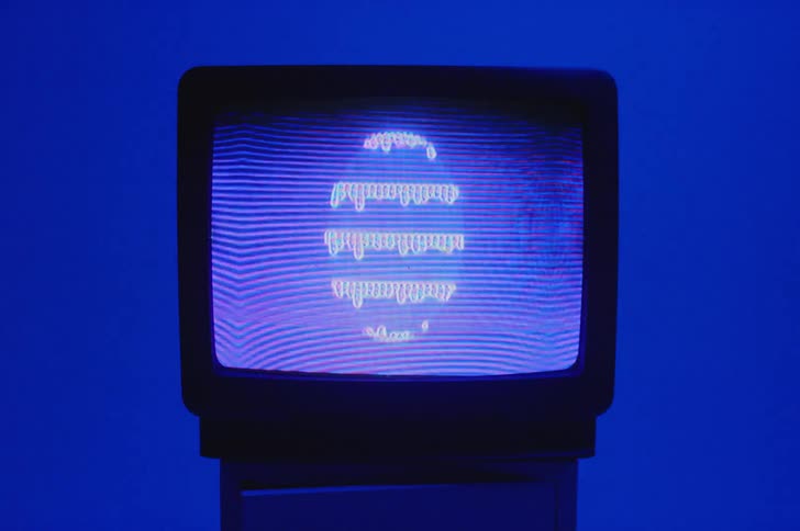 Pattern flickers on television screen in room lit by blue lighting