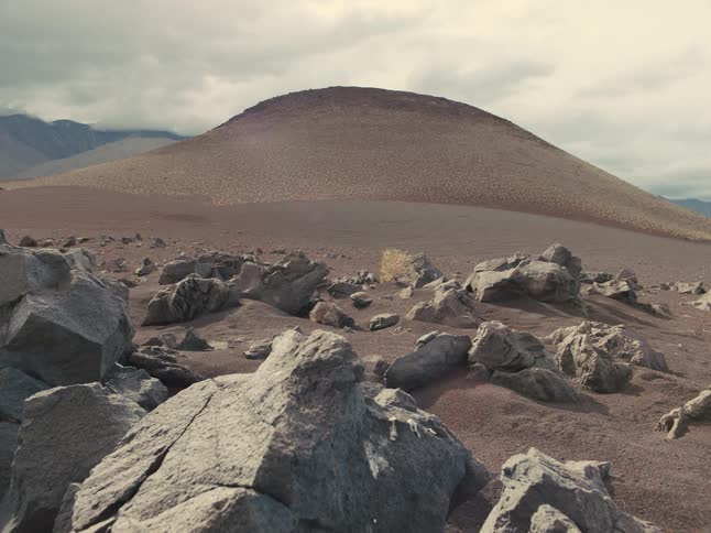 Rocks lying in front of a sandy hill