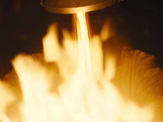 A man wears a protective mask while standing in front of a fire