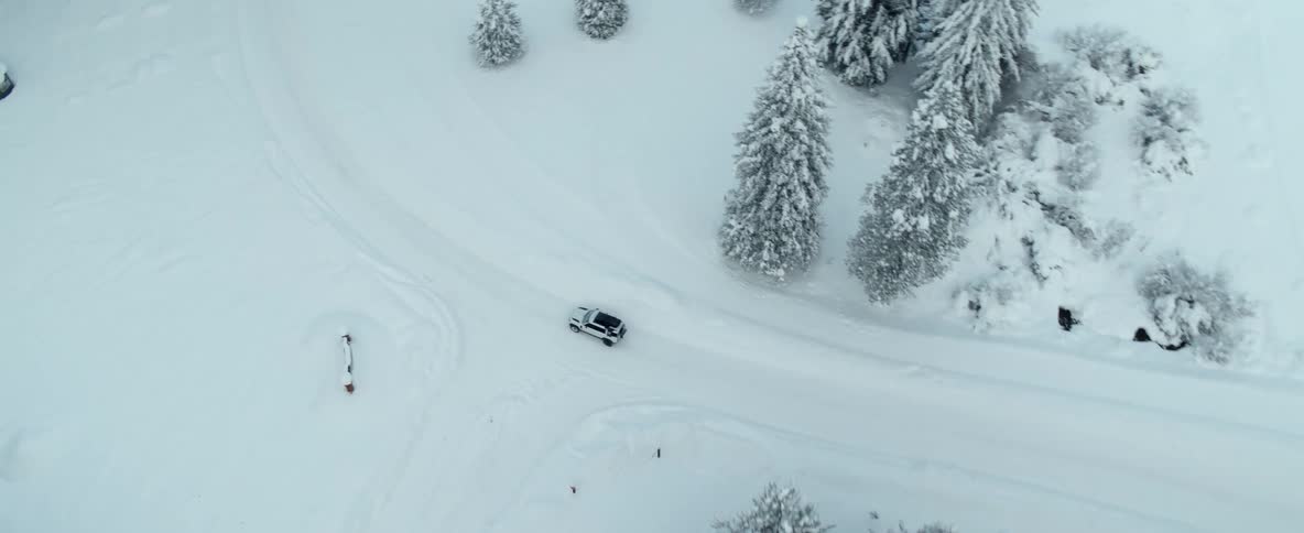 A car is driving through a rural area during the winter