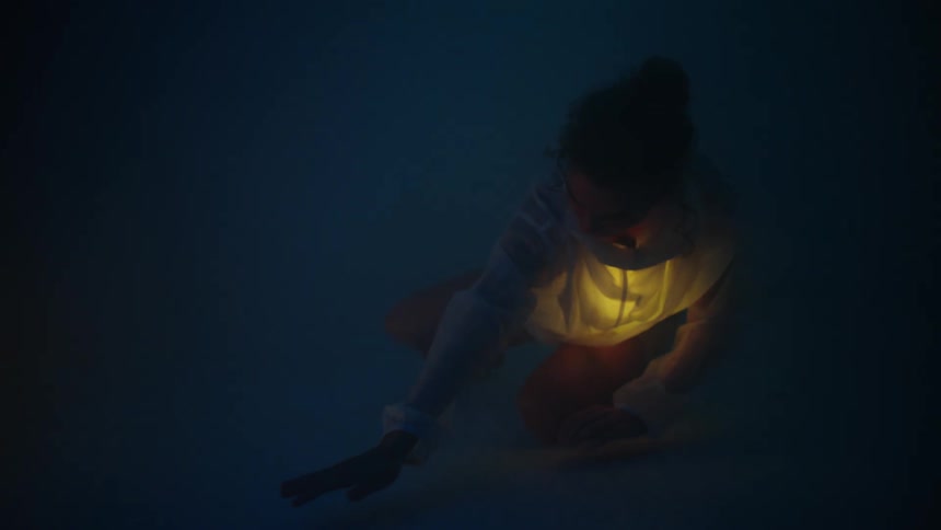 There is a young women that is dancing at night time