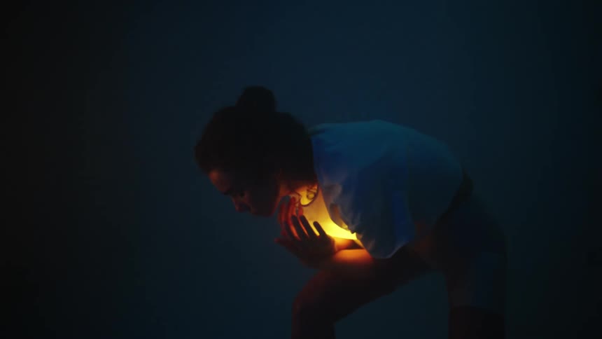 Woman with bun white t shirt and shorts dances with lamp under the shirt