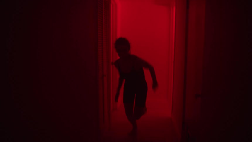 There is a young white woman that is running down the hall