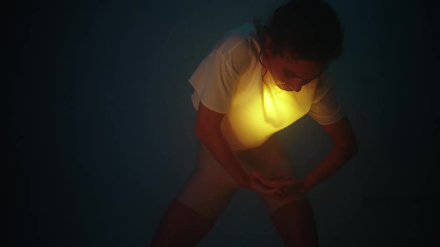 A woman is dancing outdoors at night
