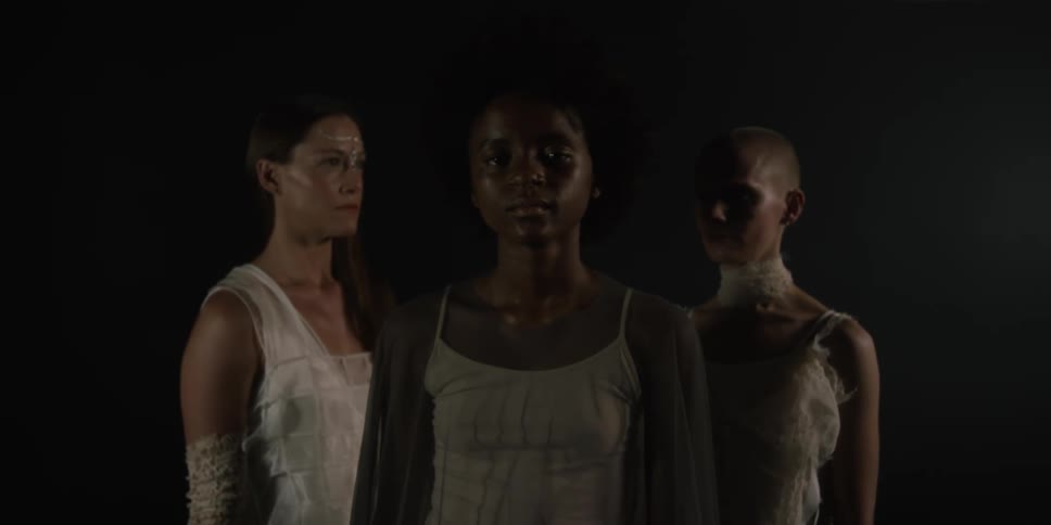 Three women are standing outdoors together at night
