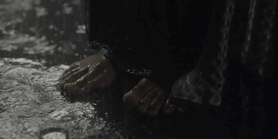 There is a person that is getting rained on outside in the night time
