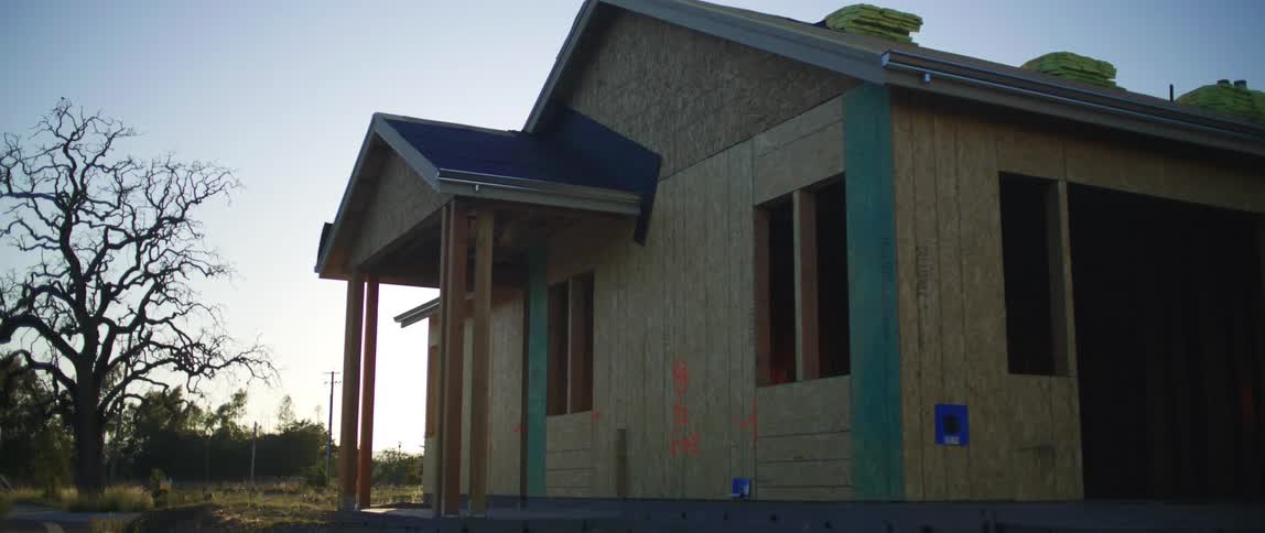 A house is being built in a rural area during dusk