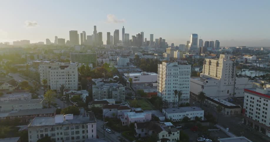 An aerial view of apartment buildings in a city with the downtown skyline in the distance