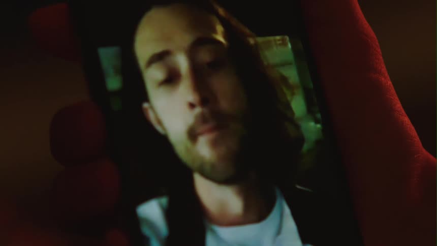 Woman holding smartphone in her hand making video call with man talking outdoors at night