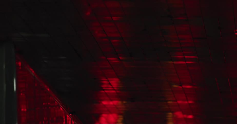 Red light reflects on ceiling of tunnel