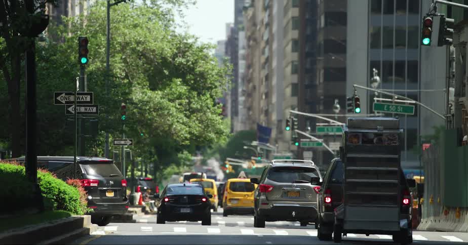 Vehicles driving and changing lanes on a busy street in new york at daytime