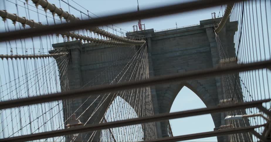 A car drive along a suspension bridge that has countless suspension cables