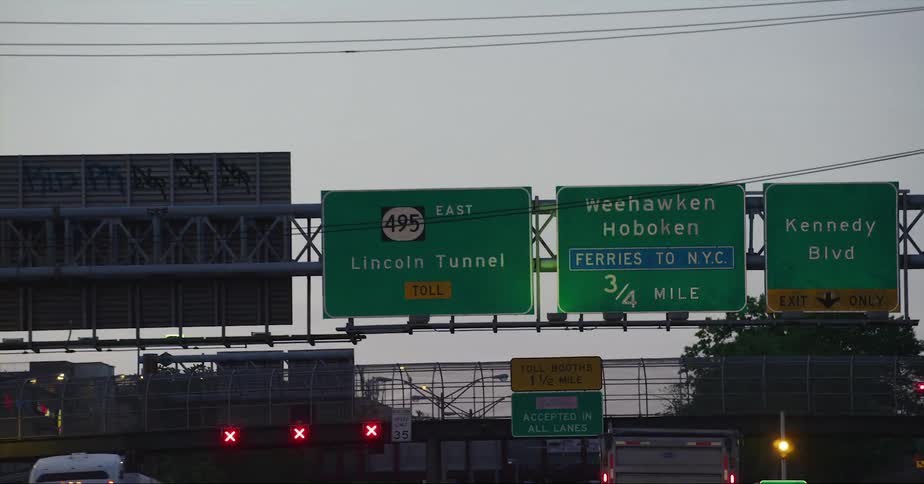 Vehicle drives on highway under green traffic signs