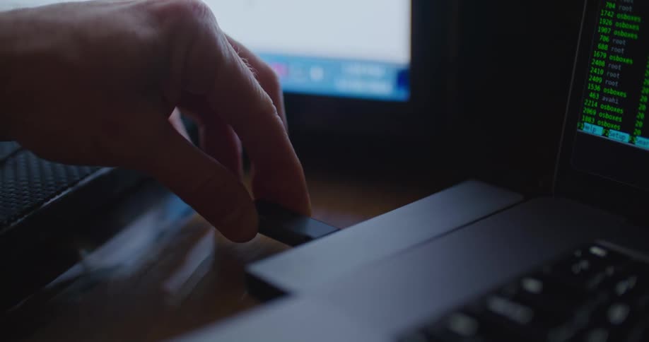 There is a person in a computer room and is by a laptop