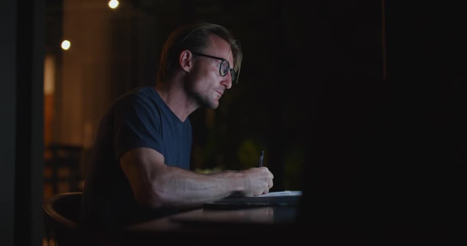 There is an older man working by some computers
