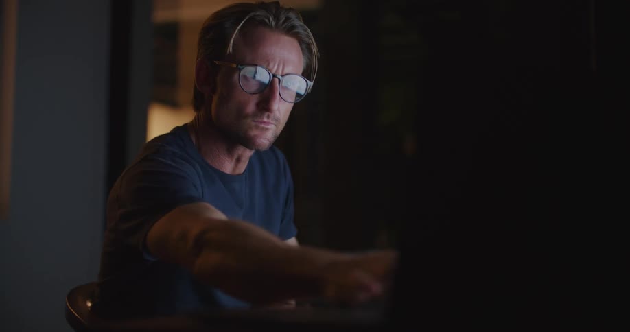 A man stares intently at his computer screen
