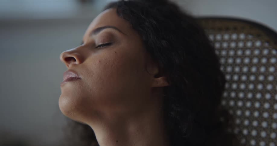 Woman rocks in chair with her eyes closed